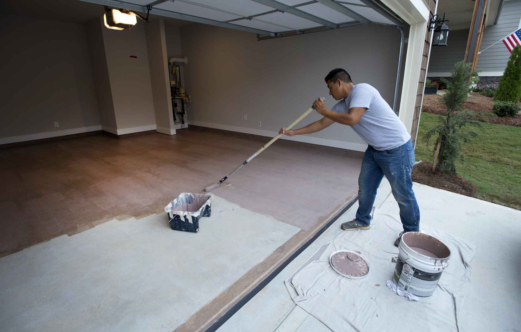 a person coating floor with mop.