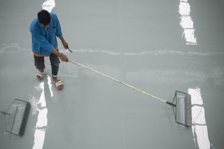 a worker coating on the concrete floor.