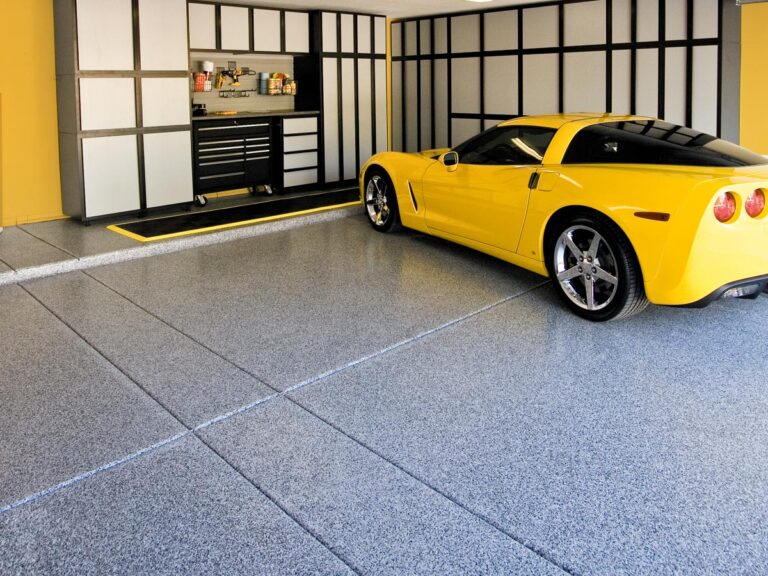 a yellow car parked on a shiny garage floor after coating.