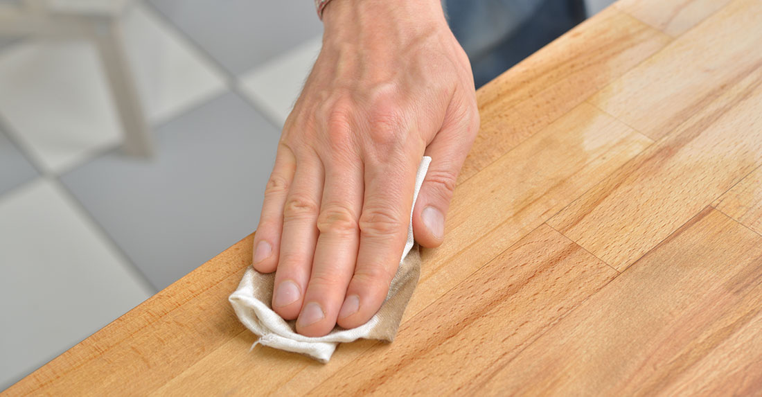 close shot of a hand waxing on wood surface.