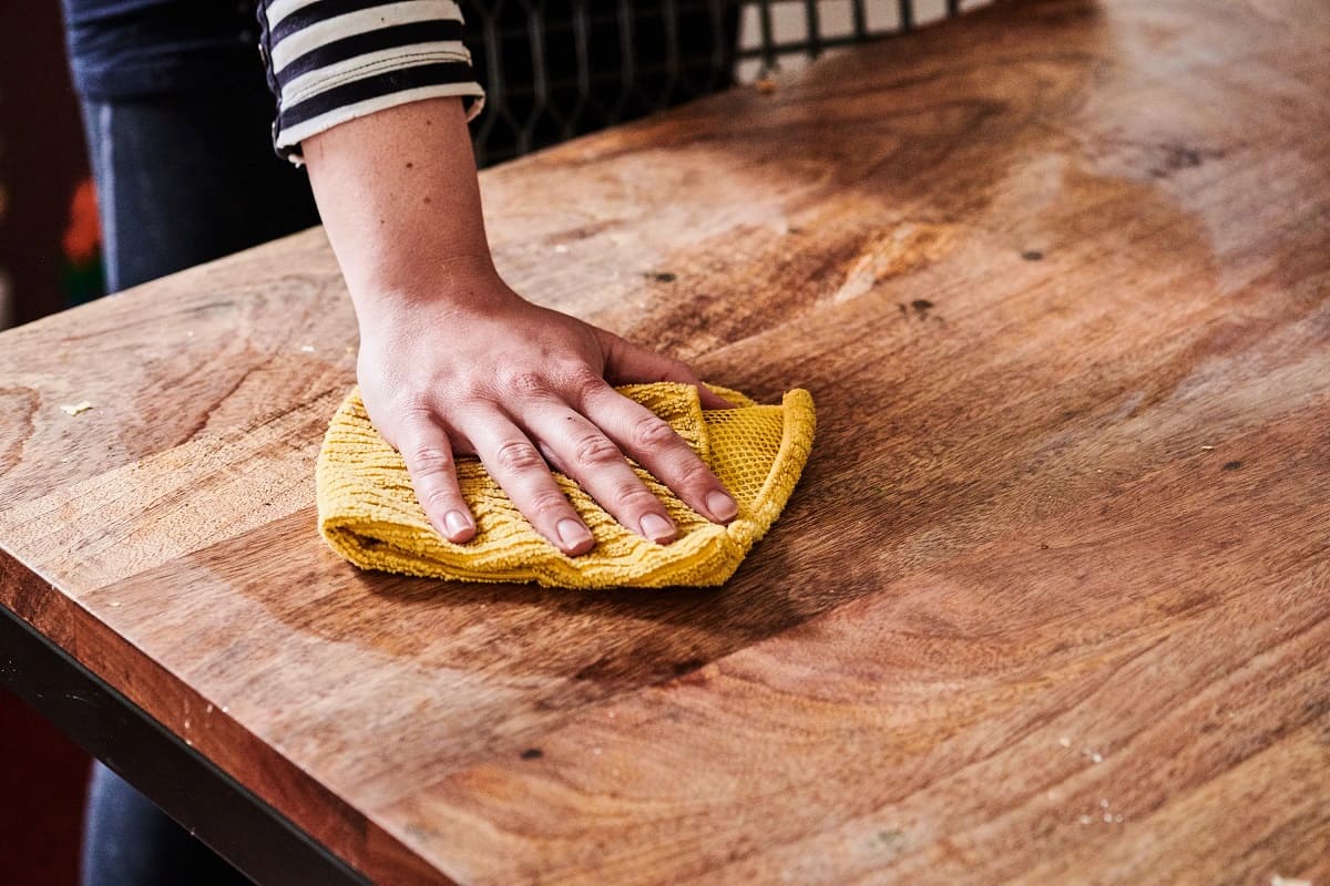 close shot of hand polishing table surface.