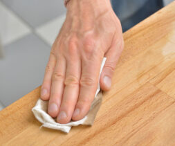close shot of a hand waxing on wood surface.